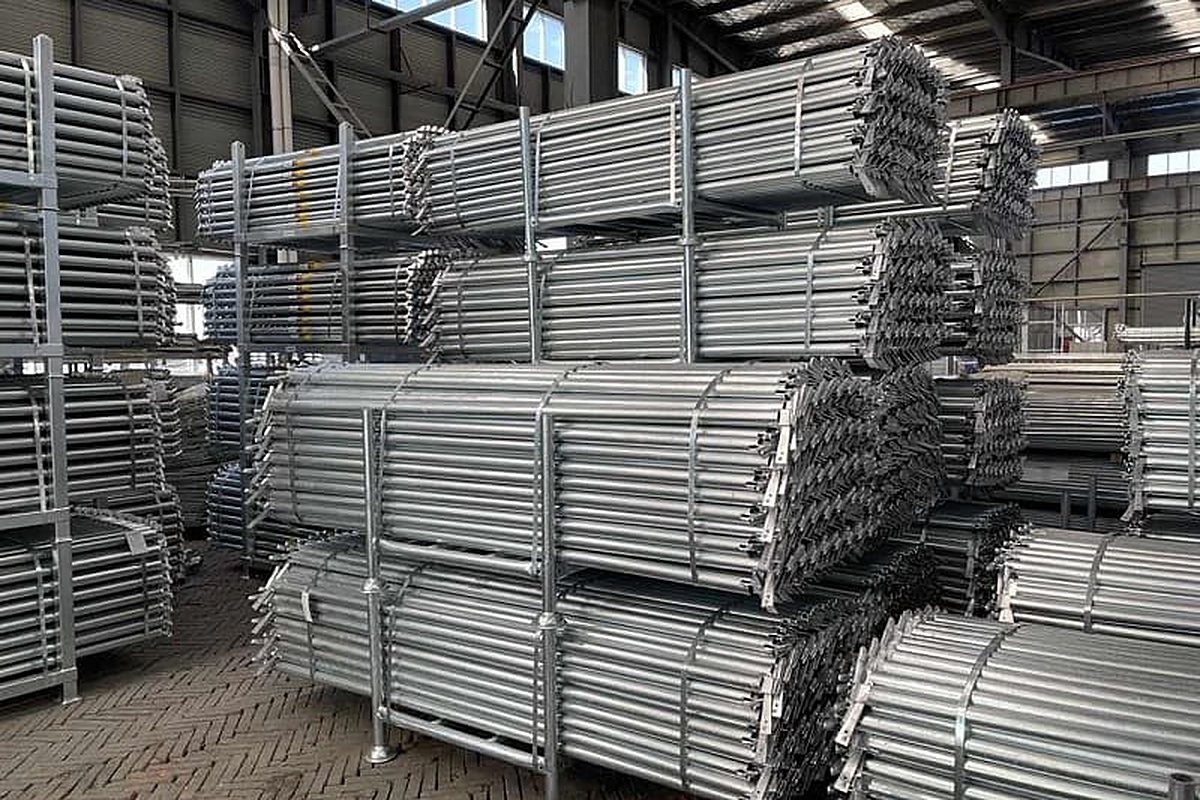 Hot-dip galvanized ringlock standards strapped in bundles on stillage racks in the factory warehouse